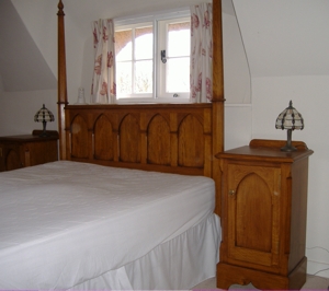 A picture of a pencil post bed headboard with matching pot cupboards